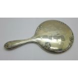 A silver backed hand mirror, silver dented