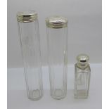 A silver topped glass scent bottle and two silver topped glass bottles, glass chipped on rim of