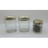 Three silver topped glass jars including one Victorian, 64g of silver, tops dented