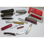 A collection of pocket knives including one Victorinox, two other multi-tool, etc.