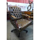 A mahogany and brown leather revolving desk chair