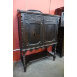A 17th Century style carved oak cupboard on stand