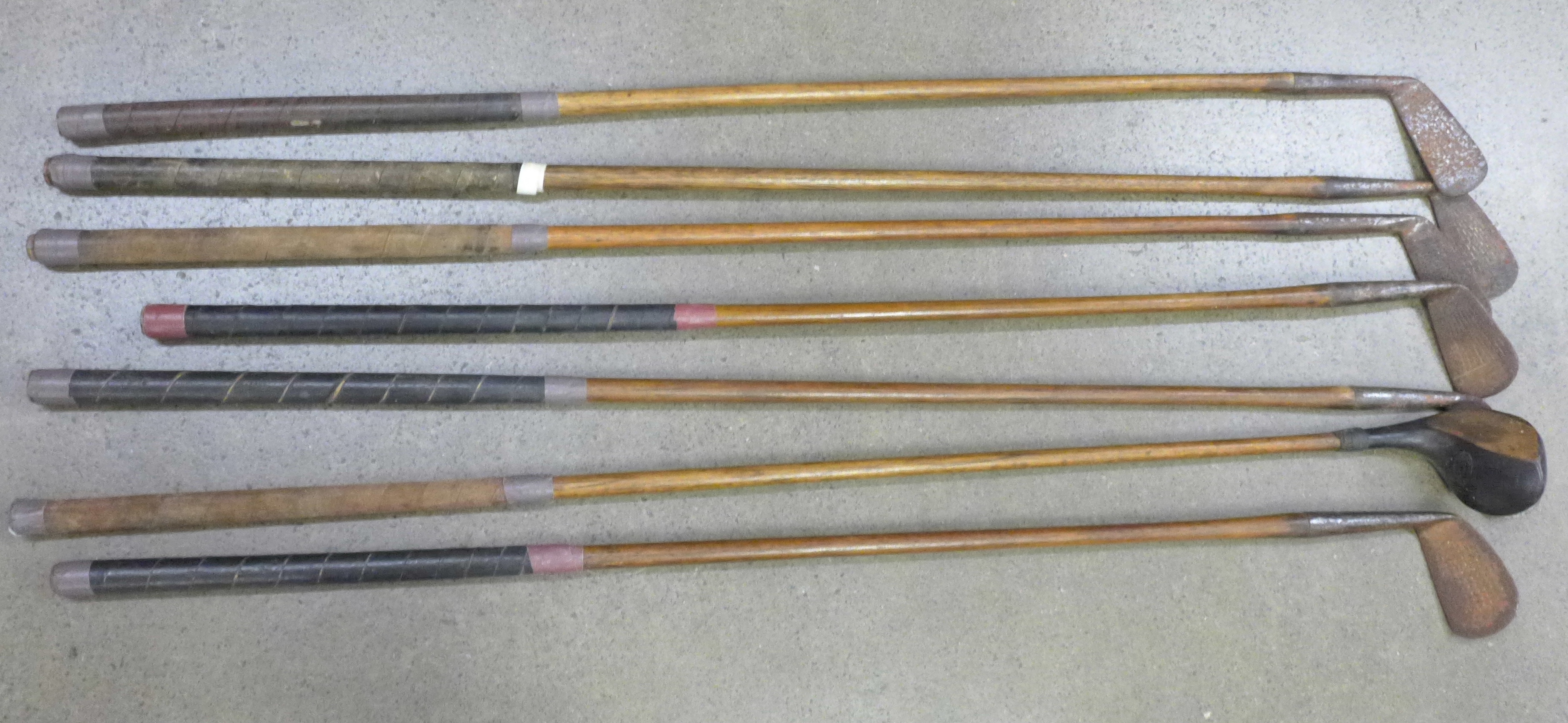 Seven hickory shafted golf clubs including Mashie made by Anderson & Sons of St. Andrews, Jiggers by