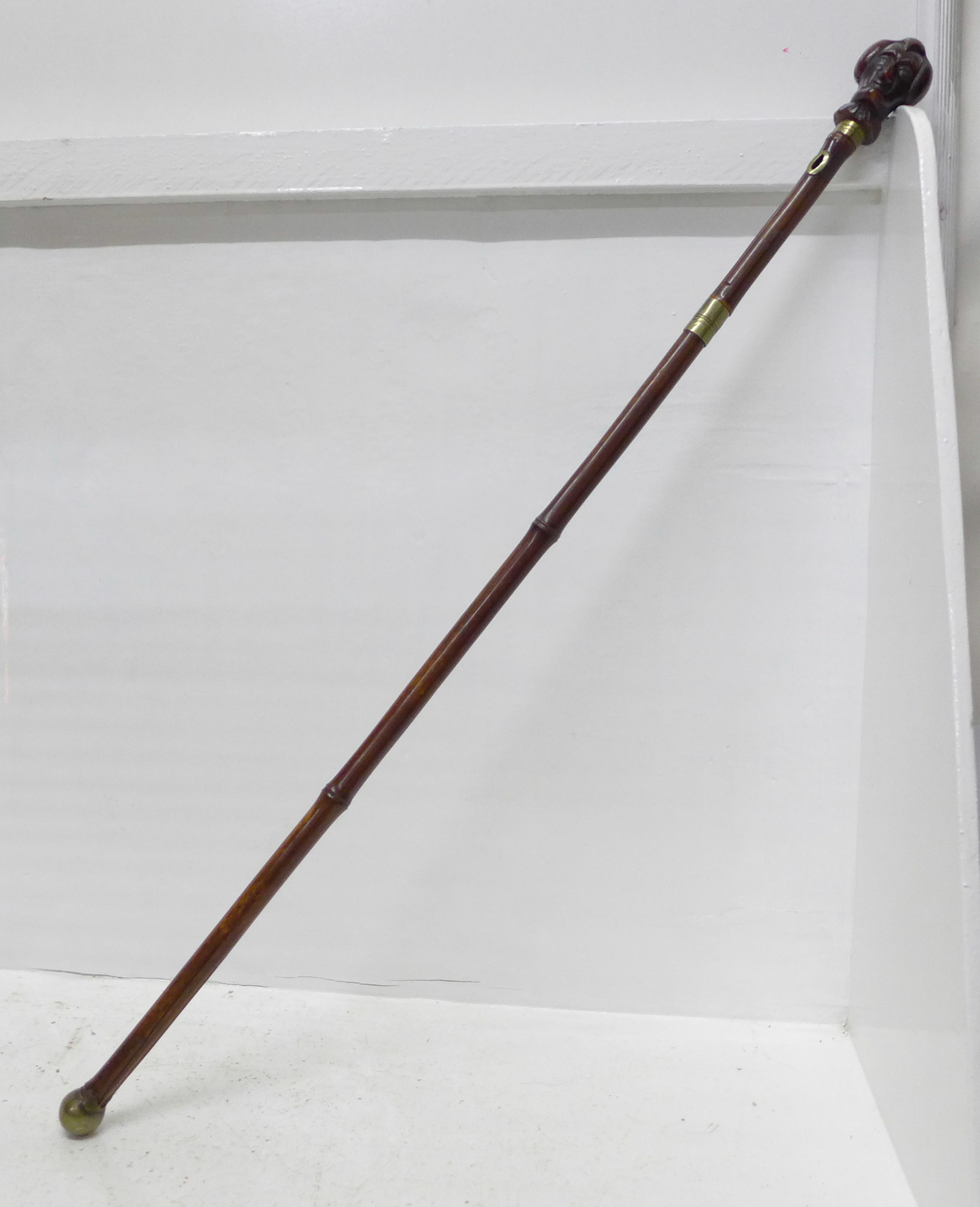 A c.1900 sword stick, with carved horn character handle and cane scabbard, blade 45.5cm