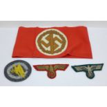 A reproduction German armband and three cloth uniform patches