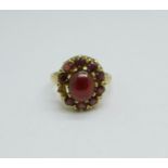 A 9ct gold and garnet cluster ring with cabochon centre stone, 4.6g, M, lacking one stone