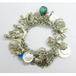 A silver charm bracelet, with fifty charms including coins, 166g