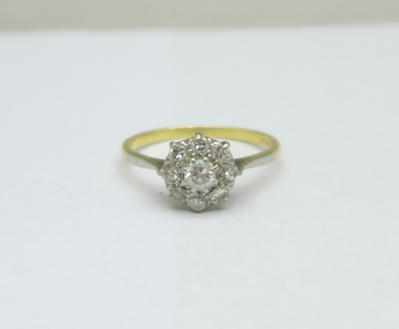 An 18ct gold and platinum set diamond cluster ring, 2.6g, S