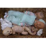 A wicker basket containing dolls **PLEASE NOTE THIS LOT IS NOT ELIGIBLE FOR POSTING AND PACKING**