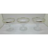 Three silver rimmed glass ice cream dishes, (chip on bottom rim of one)