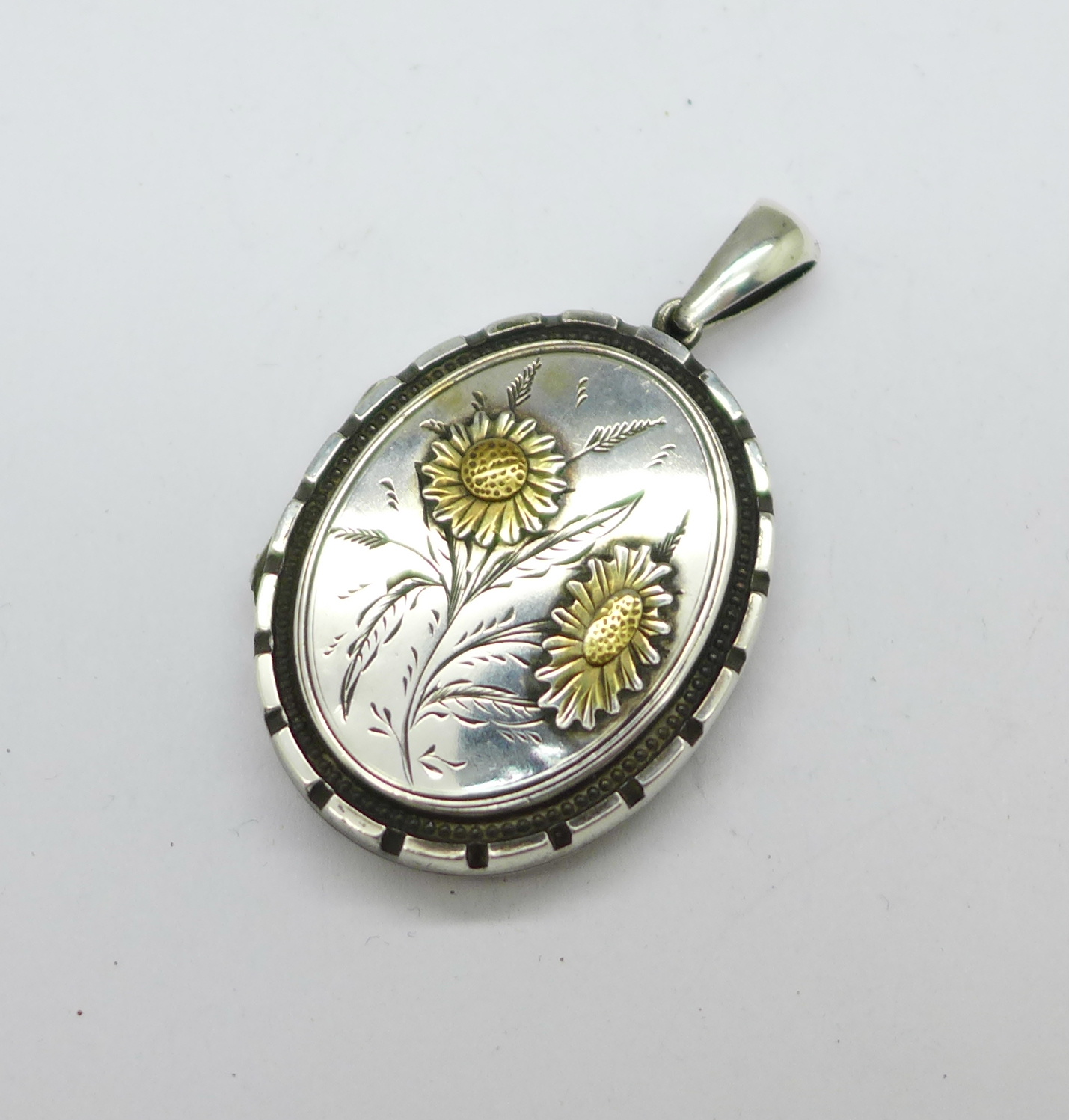 An early 20th Century white metal locket, 32mm x 40mm