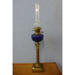 A Victorian copper and brass Corinthian column oil lamp, with Bristol blue glass reservoir