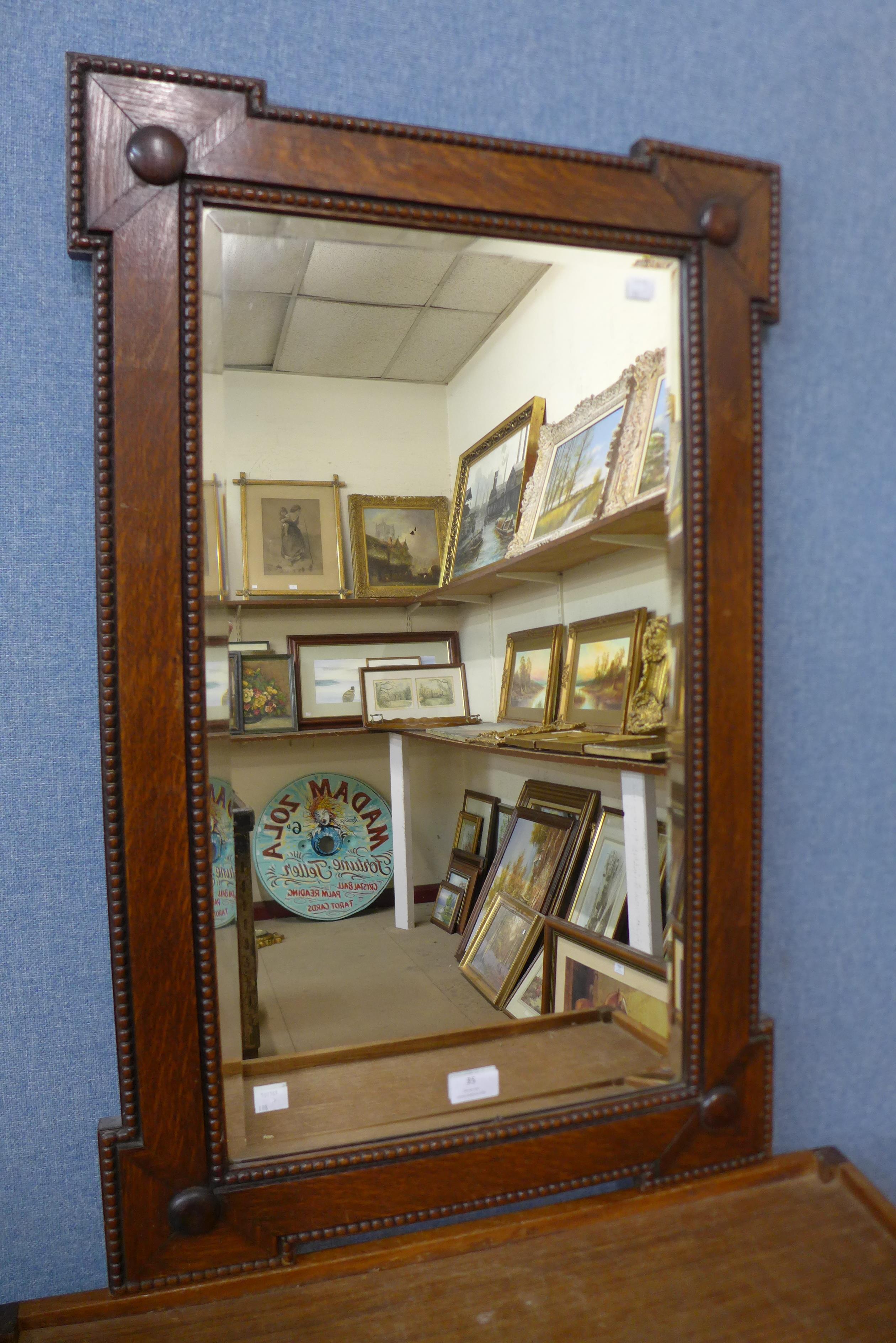 An early 20th Century carved oak mirror