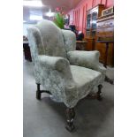 An early 20th Century Queen Anne style walnut and fabric upholstered armchair