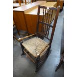 A George III elm rush seated spindle back rocking chair