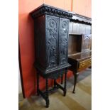 A late 19th/early 20th century carved bog oak cupboard on stand