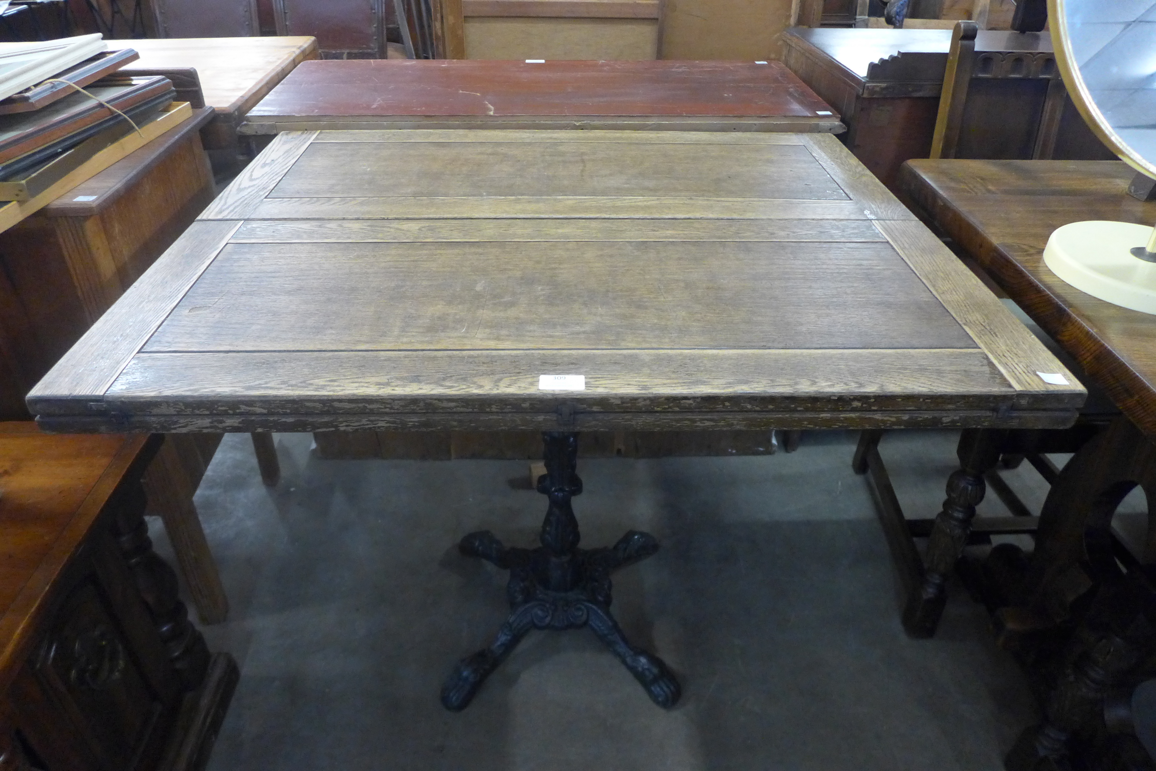 A cast iron based pub table with associated oak top