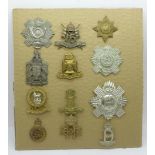 A collection of twelve military cap badges