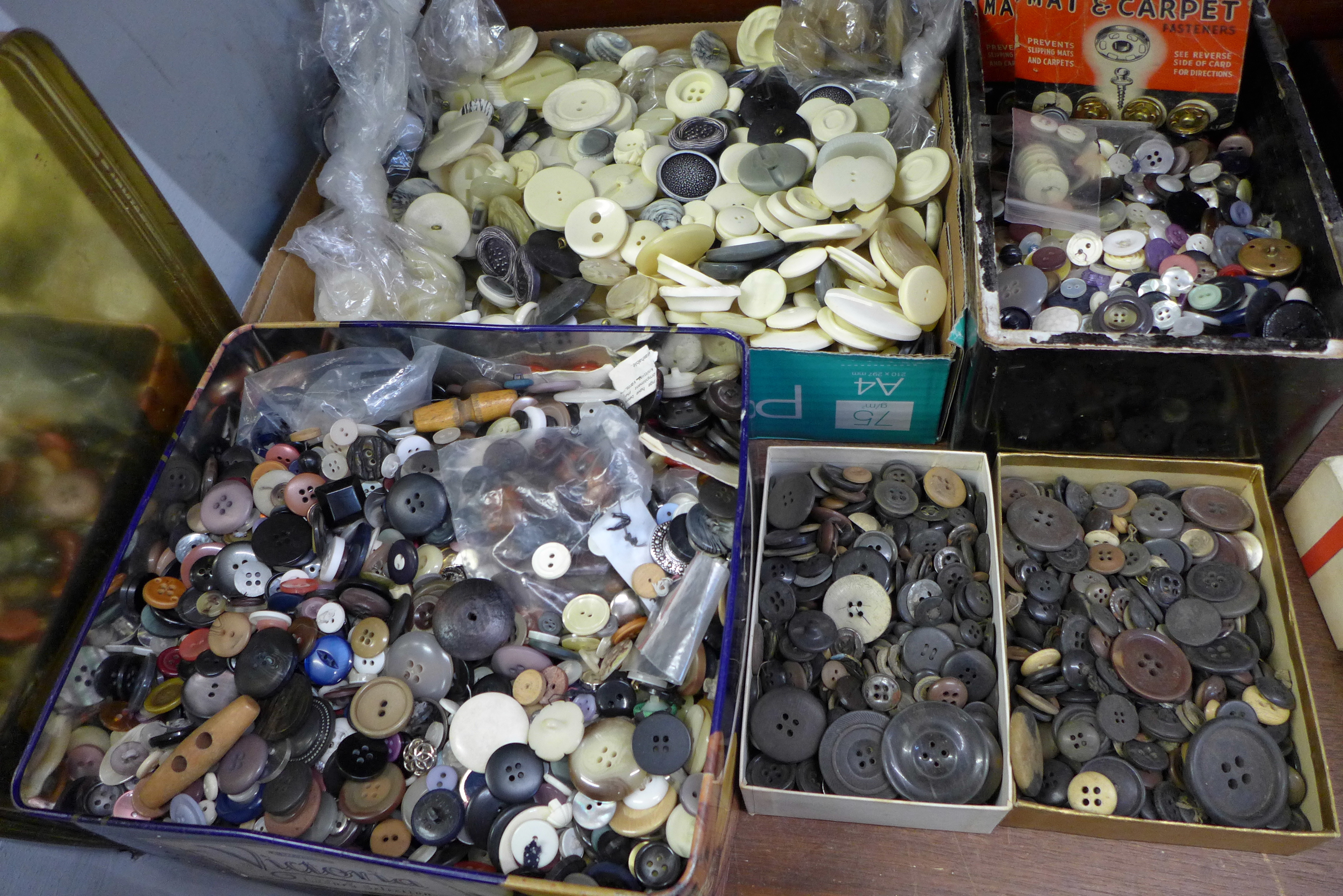 A tin and three boxes of vintage buttons and a tray of cream buttons