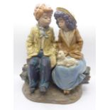 Nao by Lladro, a large figurine of a boy and girl sitting on a log, E-2S backstamp, 25.5cm