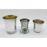 Three continental white metal shots or measures, with control marks, largest 69mm and with gilt