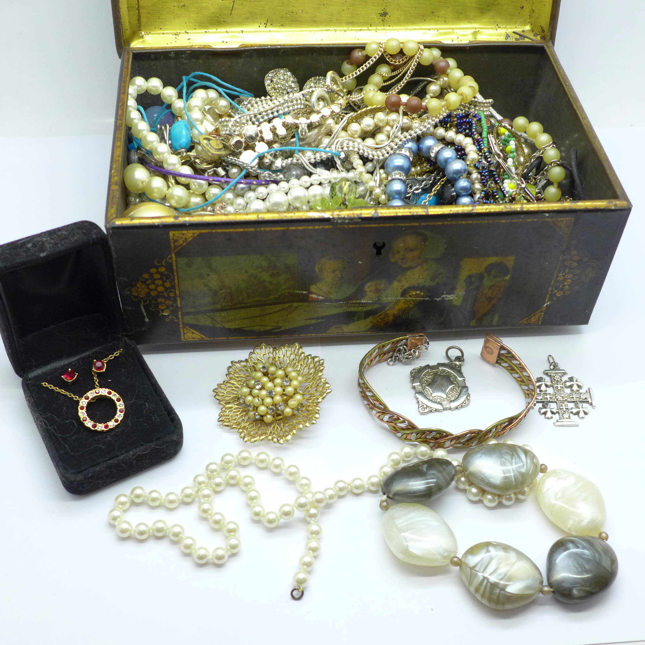 A tin of costume jewellery