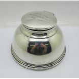 A silver inkwell, London 1931, top bears inscription, diameter of base 12cm, top dented