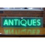 A mid 20th Century illuminated neon Antiques sign