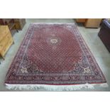 A large eastern red ground geometric patterned rug, 406 x 272cms