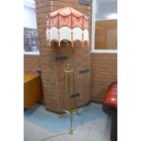 An Arts and Crafts brass floor standing lamp