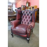 A mahogany and red leather wingback armchair