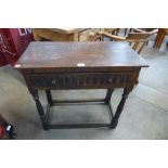 A 17th Century style carved oak single drawer side table