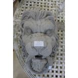 A concrete lion's mask garden ornament