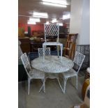 A painted circular aluminium garden table and four chairs