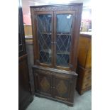 A carved oak free standing corner cabinet