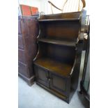 An Ercol Old Colonial elm open waterfall front bookcase