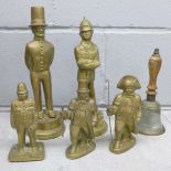 A brass hand bell and five solid brass figures, Abraham Lincoln, three policemen and one other **