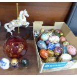 A collection of Thailand and other decorative eggs in a tray, a cranberry glass bowl and a