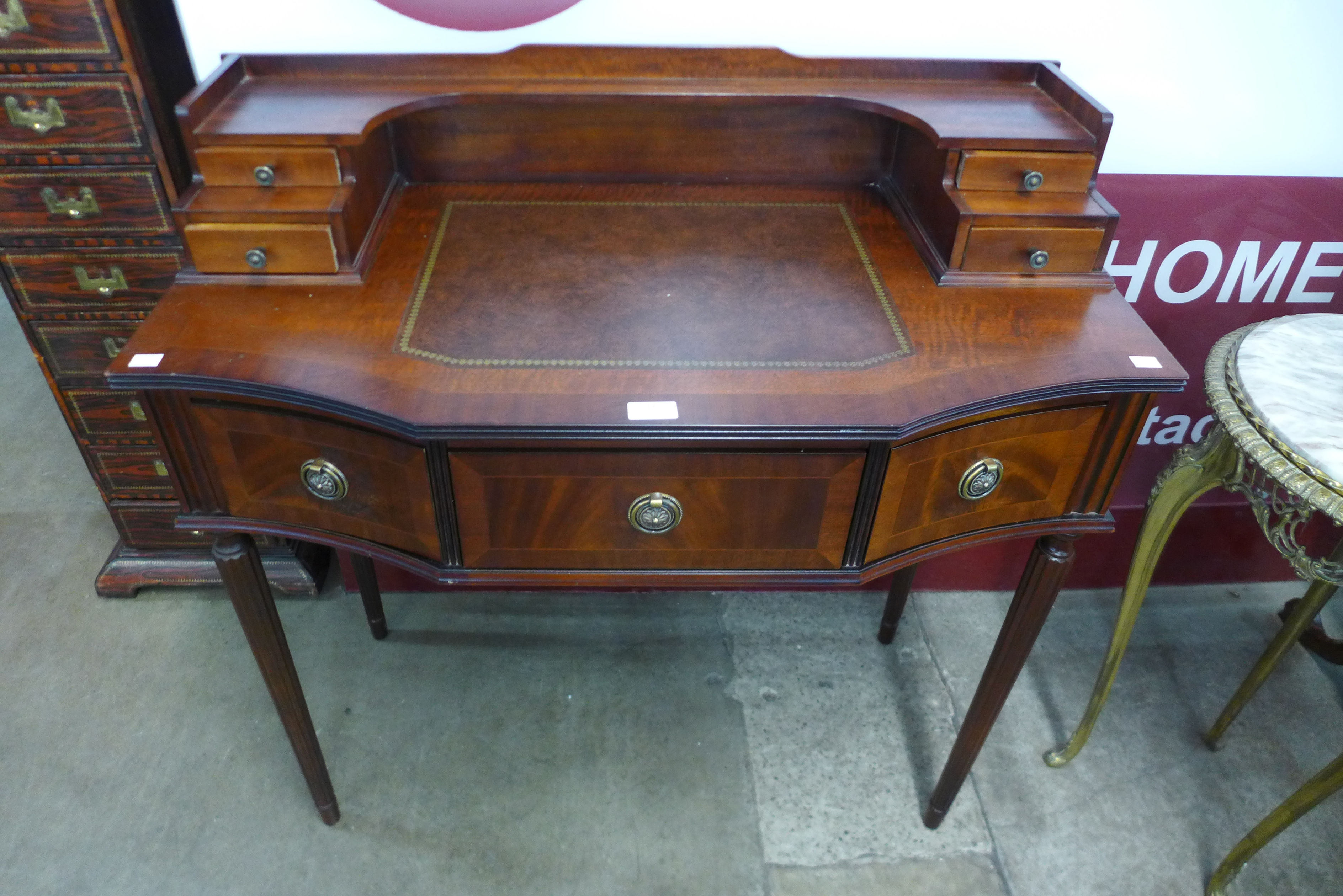 An inlaid mahogany and leather topped writing desk