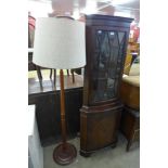 A mahogany freestanding corner cabinet and a standard lamp