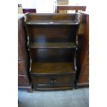 An Ercol Old Colonial elm open waterfall front bookcase