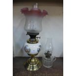 Two oil lamps, one with pink edged glass shade