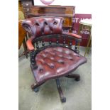 A mahogany and buttoned ox blood leather revolving desk chair