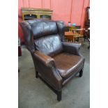 A mahogany and studded chestnut brown leather wingback armchair