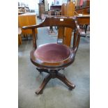 A mahogany and fabric seated revolving desk chair