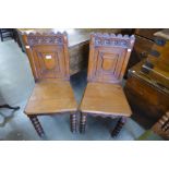 A pair of Victorian Gothic Revival oak hall chairs