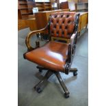 A mahogany and leather upholstered revolving desk chair