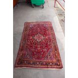A hand made eastern red ground rug