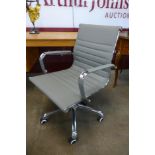 An Eames style chrome and grey leather revolving desk chair