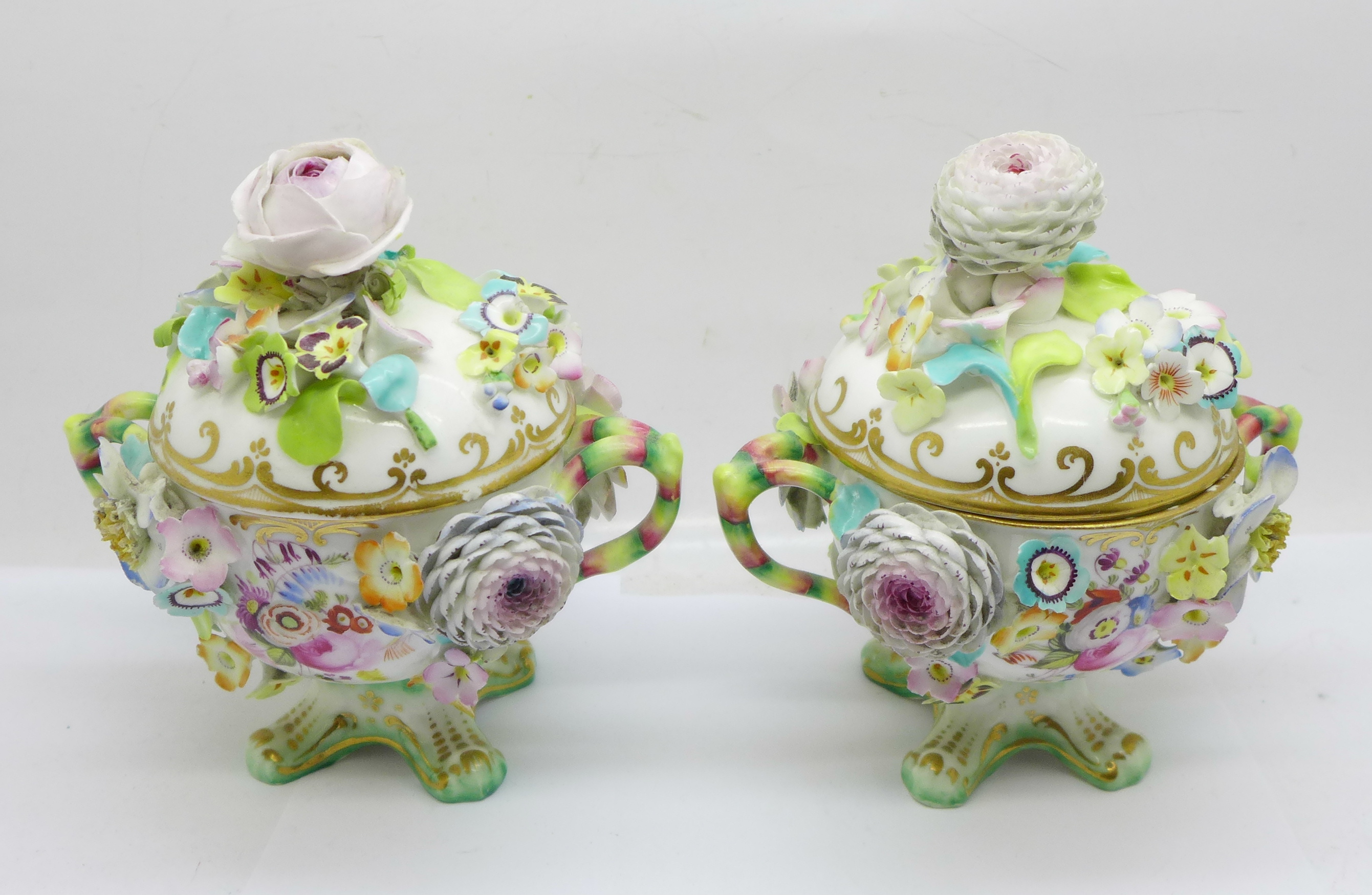 A pair of continental florally encrusted lidded pots, 14cm, some petals a/f